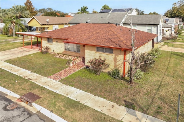 view of front of property featuring a front yard and a carport