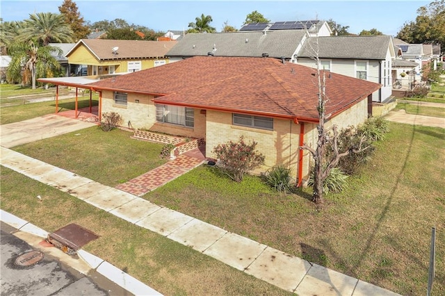 6301 S Rocheblave St, New Orleans, LA 70125 - view of front of house with a residential view, concrete driveway, a front yard, and an attached carport