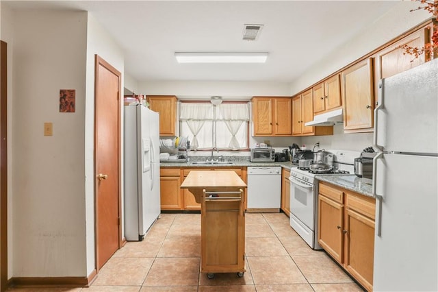 kitchen featuring light tile patterned floors, white appliances, a center island, and sink