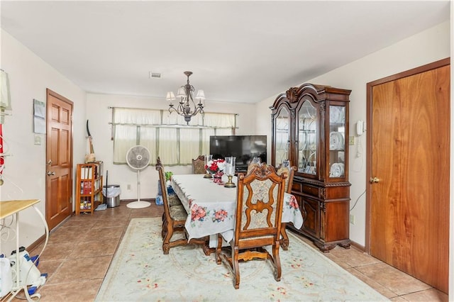 dining space with light tile patterned floors and a chandelier