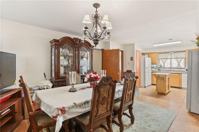 tiled dining space featuring an inviting chandelier