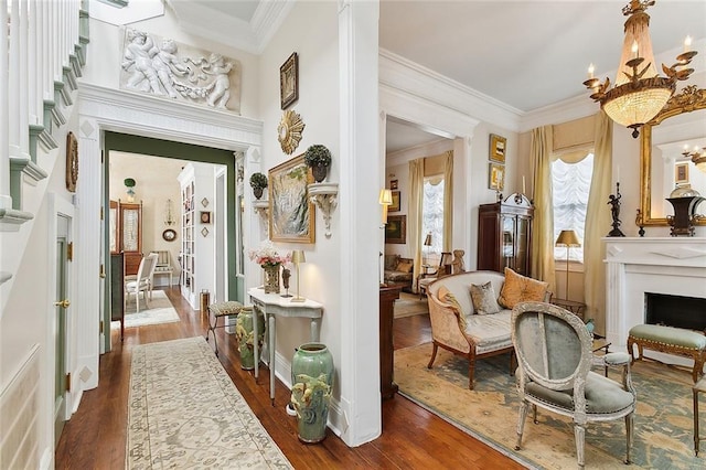 hall featuring wood-type flooring, ornamental molding, and a notable chandelier