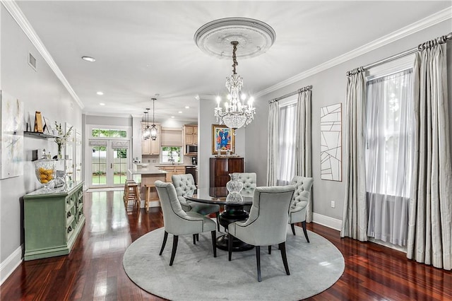 dining space featuring french doors, dark hardwood / wood-style floors, ornamental molding, and a notable chandelier