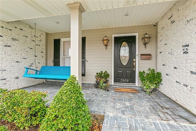 view of exterior entry with a porch