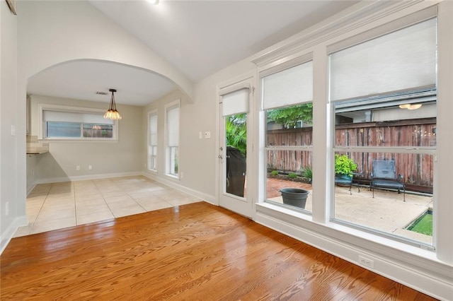 entryway featuring a wealth of natural light, light hardwood / wood-style flooring, and vaulted ceiling