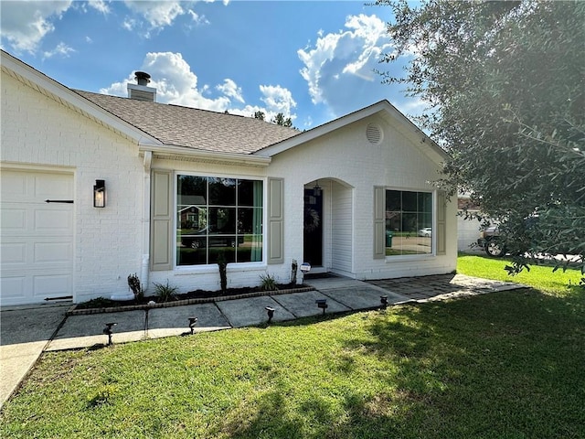 view of front of house with a front yard and a garage