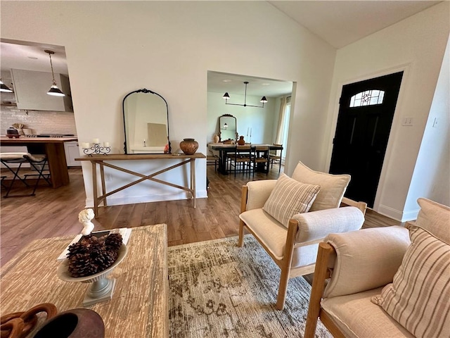 living room with hardwood / wood-style floors, high vaulted ceiling, and an inviting chandelier