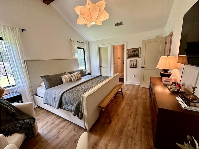 bedroom with vaulted ceiling and hardwood / wood-style flooring