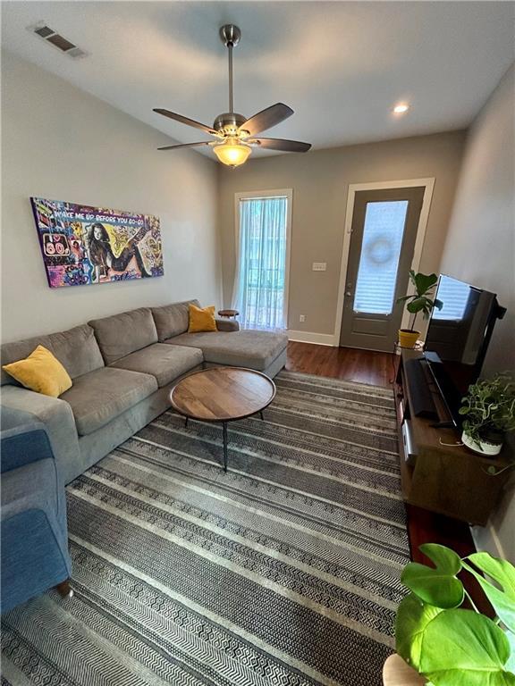 living room with ceiling fan and dark hardwood / wood-style floors