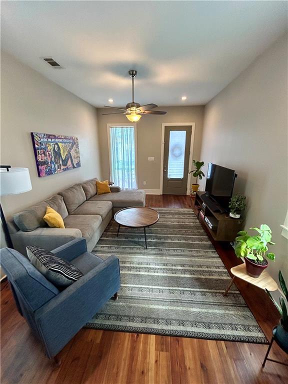 living room with ceiling fan and dark hardwood / wood-style floors