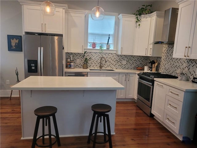 kitchen featuring sink, white cabinets, wall chimney range hood, and appliances with stainless steel finishes