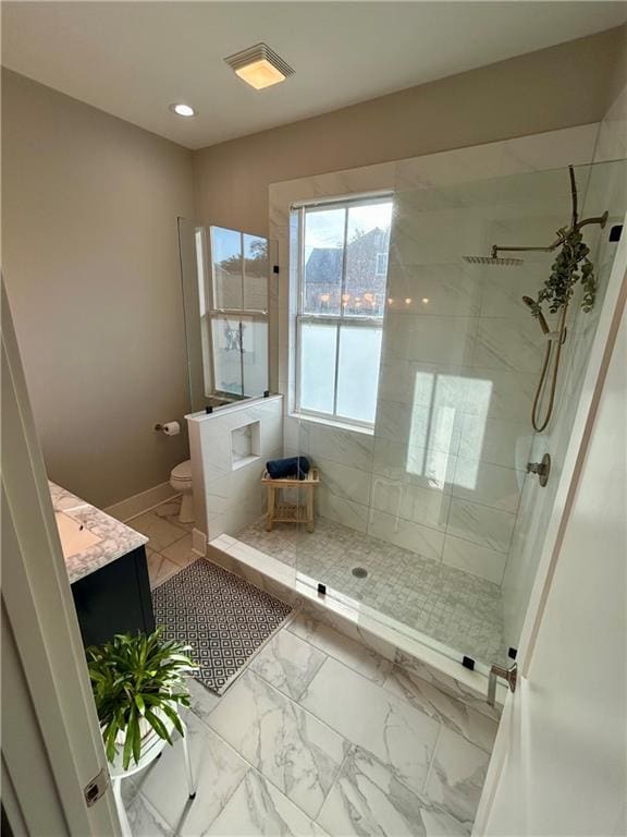 bathroom featuring toilet, a tile shower, and vanity