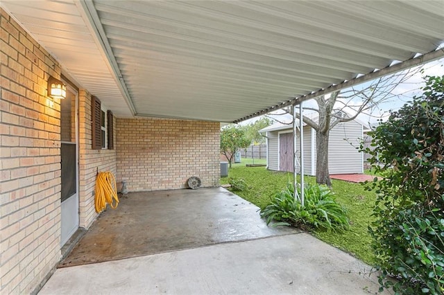 view of patio / terrace with a shed, central AC unit, and a carport