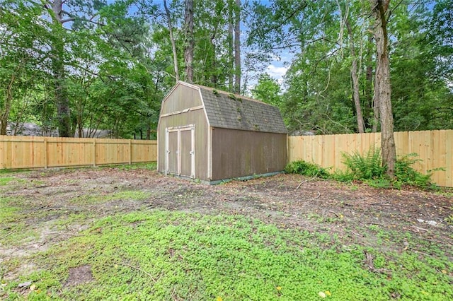 view of yard with a storage shed, a fenced backyard, and an outbuilding