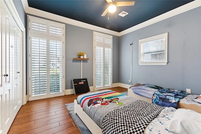 bedroom featuring ceiling fan, ornamental molding, and hardwood / wood-style flooring