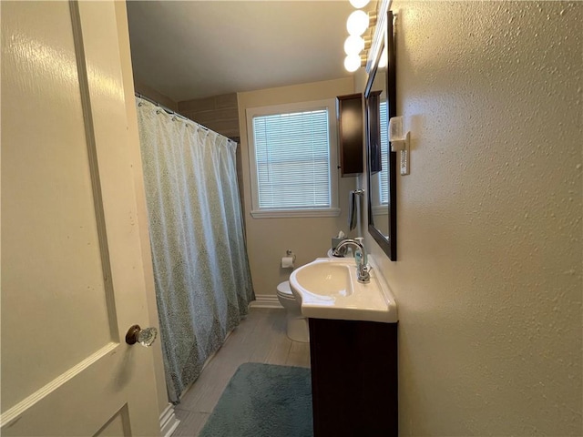 bathroom with hardwood / wood-style flooring, vanity, and toilet