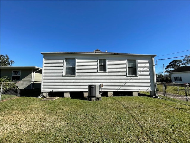 back of property featuring a lawn and cooling unit