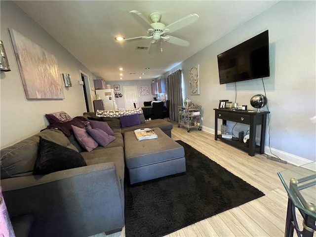 living room featuring ceiling fan and light hardwood / wood-style floors