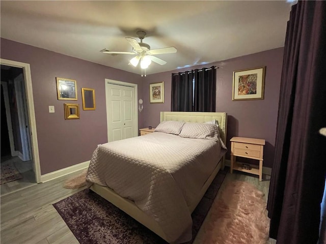 bedroom with ceiling fan, a closet, and wood-type flooring