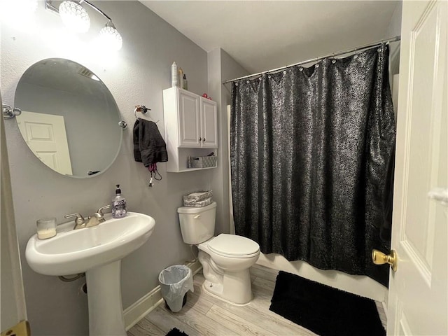 bathroom with hardwood / wood-style flooring, toilet, and walk in shower