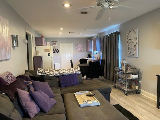 living room with ceiling fan and light hardwood / wood-style flooring