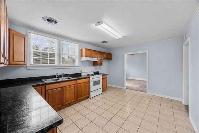 kitchen featuring white range with gas stovetop, light tile patterned flooring, crown molding, and sink