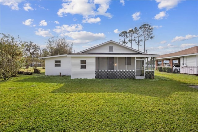 rear view of property featuring a lawn and a sunroom