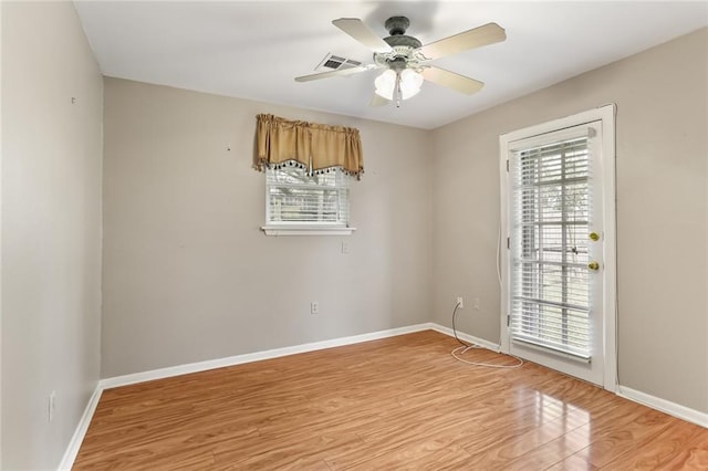 empty room featuring ceiling fan, a healthy amount of sunlight, and light hardwood / wood-style floors