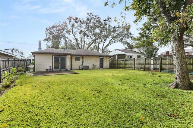 back of house featuring a lawn, central air condition unit, and a patio