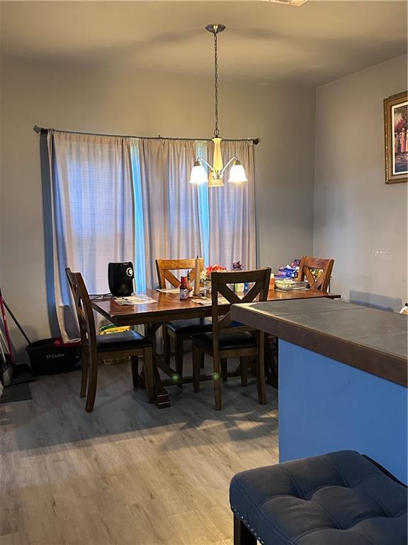 dining space with hardwood / wood-style flooring and an inviting chandelier