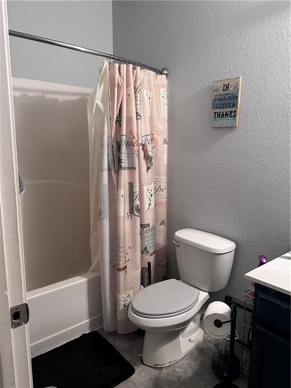 full bathroom with shower / bath combo, toilet, and vanity