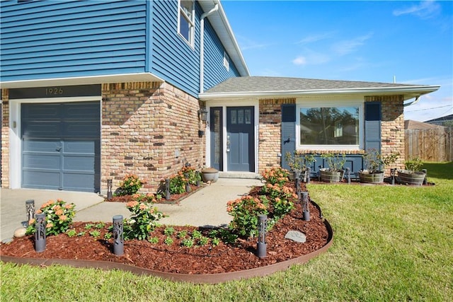 view of exterior entry with a garage and a lawn