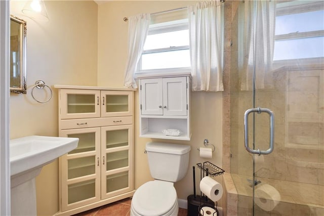 bathroom featuring tile patterned flooring, an enclosed shower, and toilet