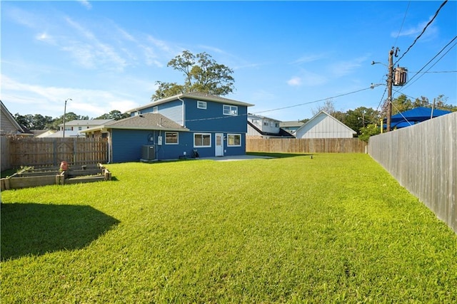 back of house featuring central air condition unit and a lawn