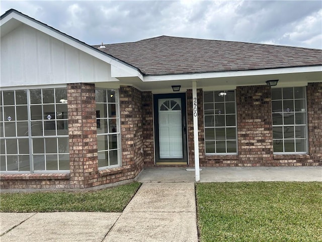 property entrance with a lawn