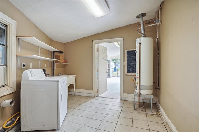 washroom featuring washer / dryer, light tile patterned floors, sink, and gas water heater