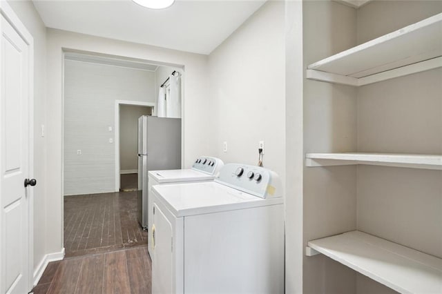 washroom with washer and clothes dryer and dark wood-type flooring