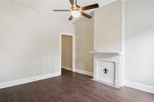 unfurnished living room featuring ceiling fan and dark wood-type flooring