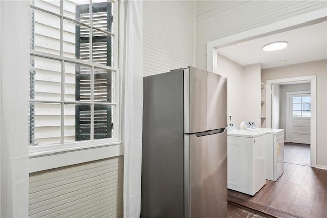 kitchen featuring washing machine and clothes dryer, stainless steel fridge, dark hardwood / wood-style flooring, and white cabinets