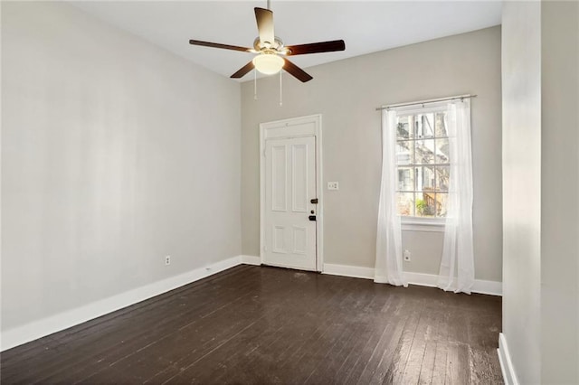 spare room with dark hardwood / wood-style flooring and ceiling fan