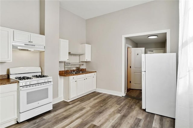 kitchen featuring white cabinets, white appliances, and hardwood / wood-style flooring