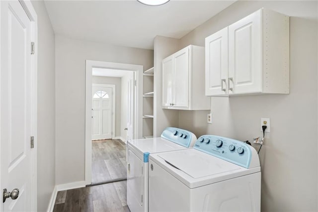 laundry room featuring washer and clothes dryer, cabinets, and light wood-type flooring