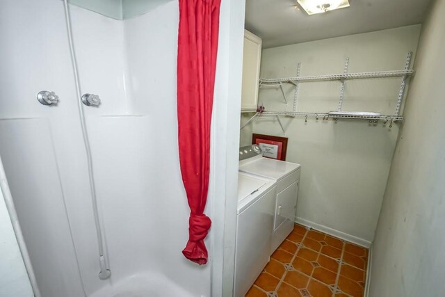 laundry room featuring dark tile patterned flooring, cabinets, and independent washer and dryer