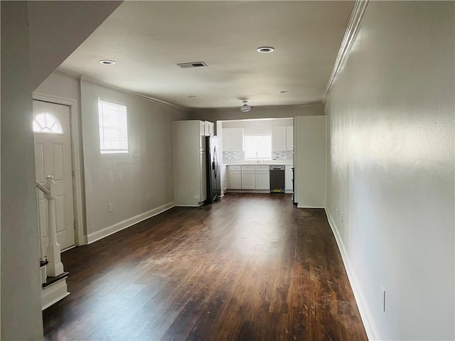 unfurnished living room featuring crown molding, dark hardwood / wood-style flooring, and sink