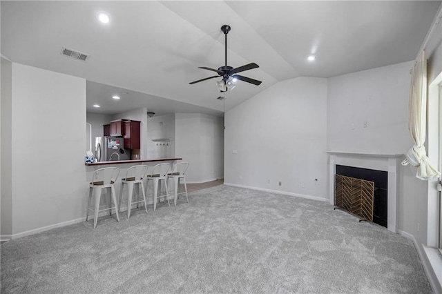 carpeted living room with vaulted ceiling and ceiling fan