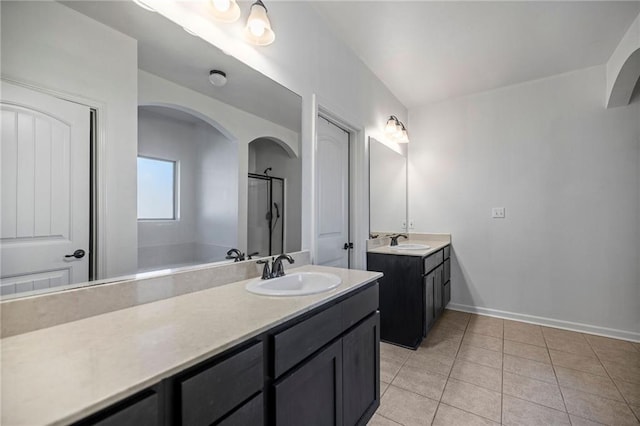 bathroom with a shower, vanity, and tile patterned floors