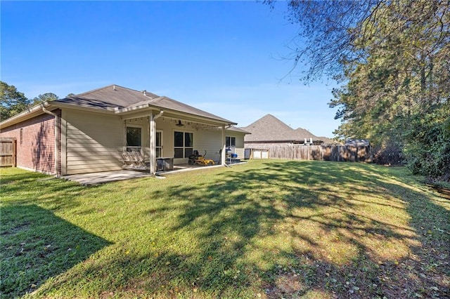 rear view of property with a patio area and a yard