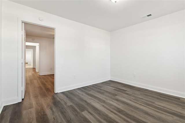 spare room with dark wood-type flooring