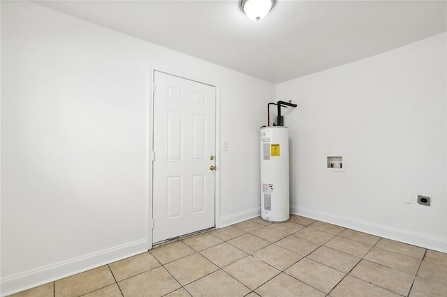 clothes washing area with hookup for an electric dryer, washer hookup, light tile patterned floors, and water heater