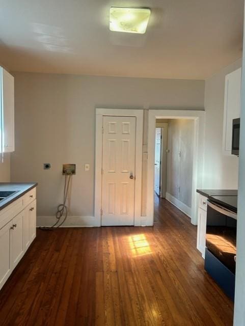 kitchen featuring black range with electric stovetop, white cabinetry, and dark hardwood / wood-style floors